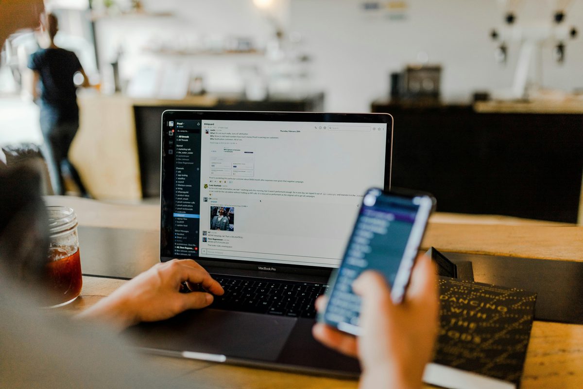 Professional using applications from a phone and laptop